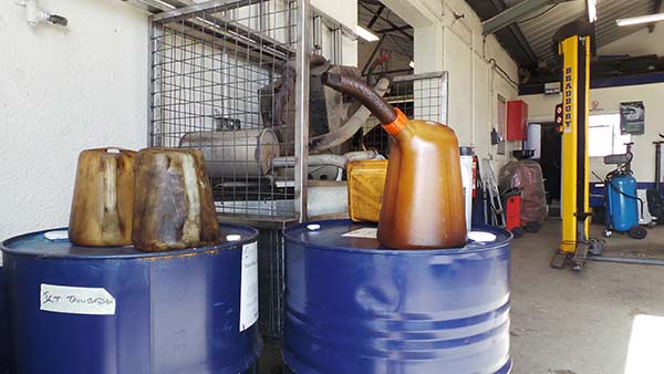 Oil drums and used parts by the lifts in the workshop